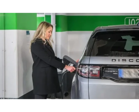 A woman charges her vehicle